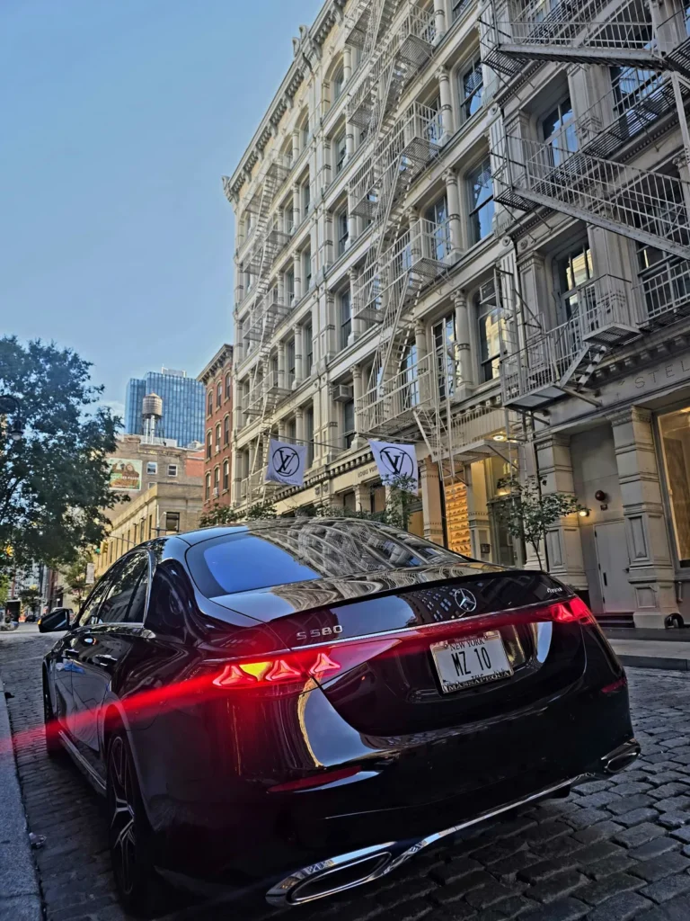 Rear view of the MZ RIDE Mercedes-Benz S580 sedan on a SoHo cobblestone street in Manhattan